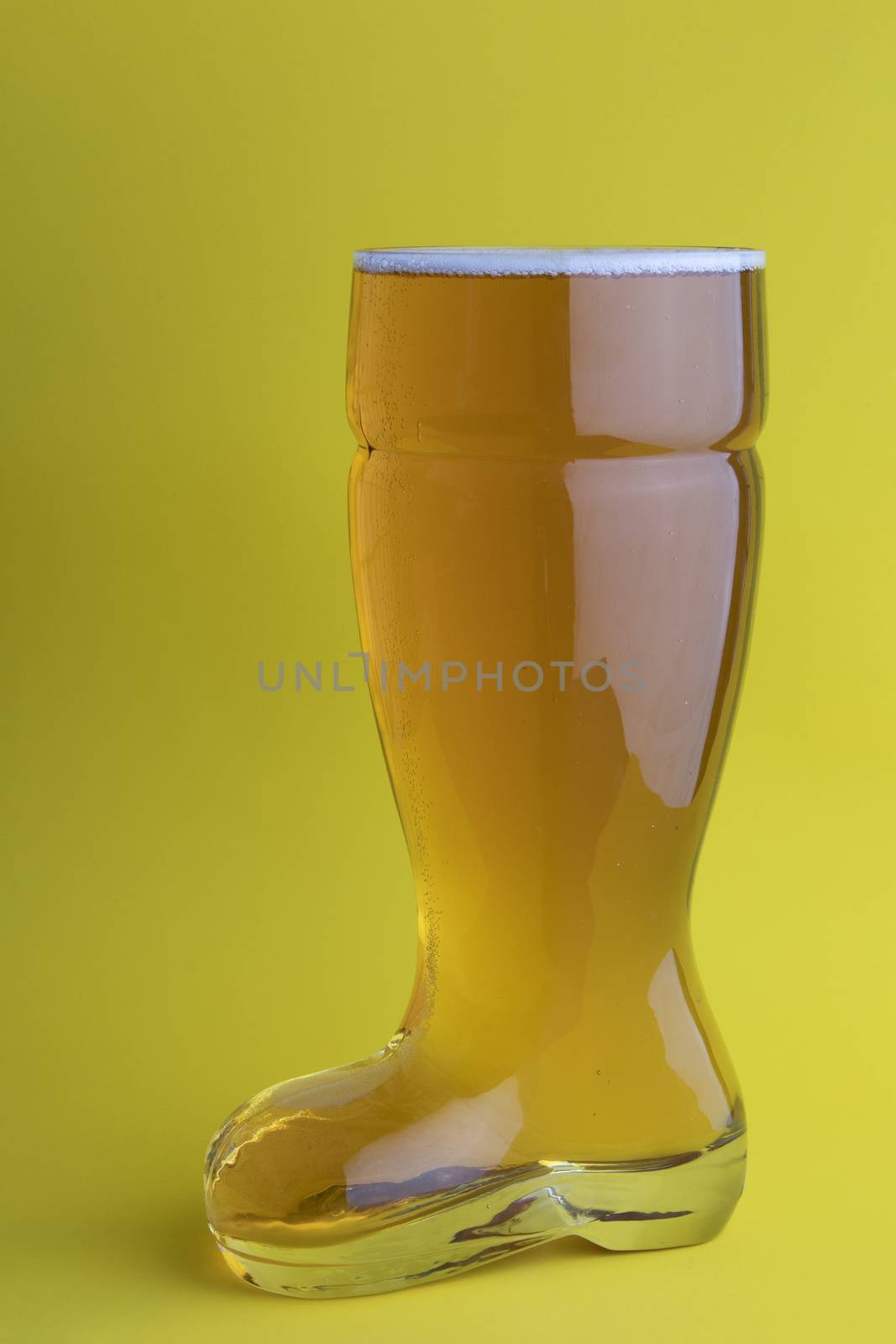 Beer in a boot beer glass in yellow background by oasisamuel
