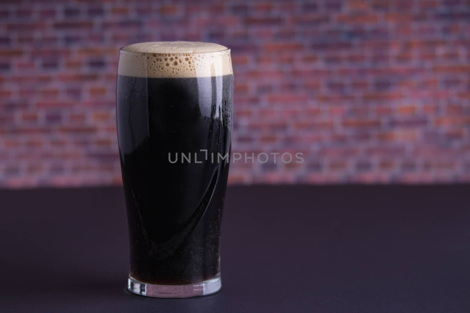 A Guinness dark Irish dry stout beer glass that originated in the brewery in dublin horizontal view