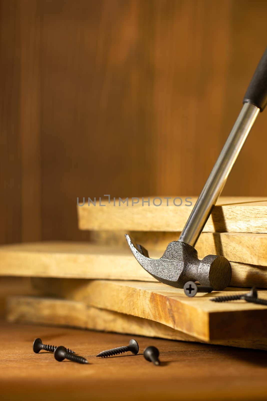 Hammer and screw on lumber in lighting and shadow. by SaitanSainam