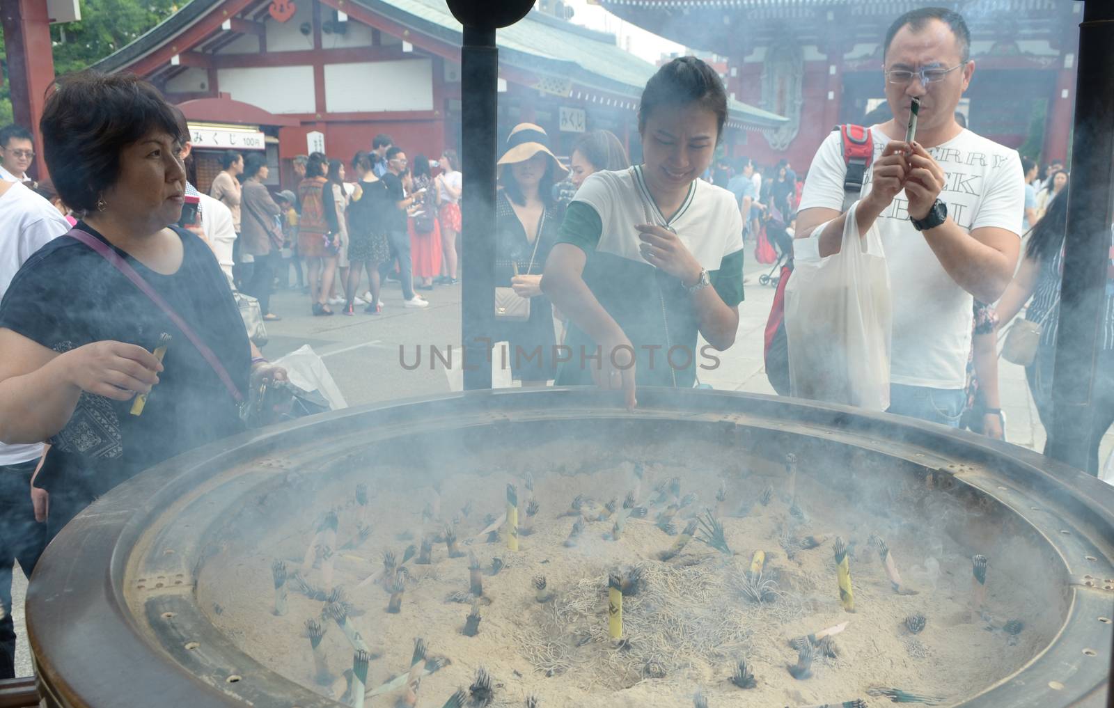 Tokyo, Japan - May 28, 2018: Soft focus The People beckons smoke for lucky from the giant incense burner at Asakusa Sensoji Temple.