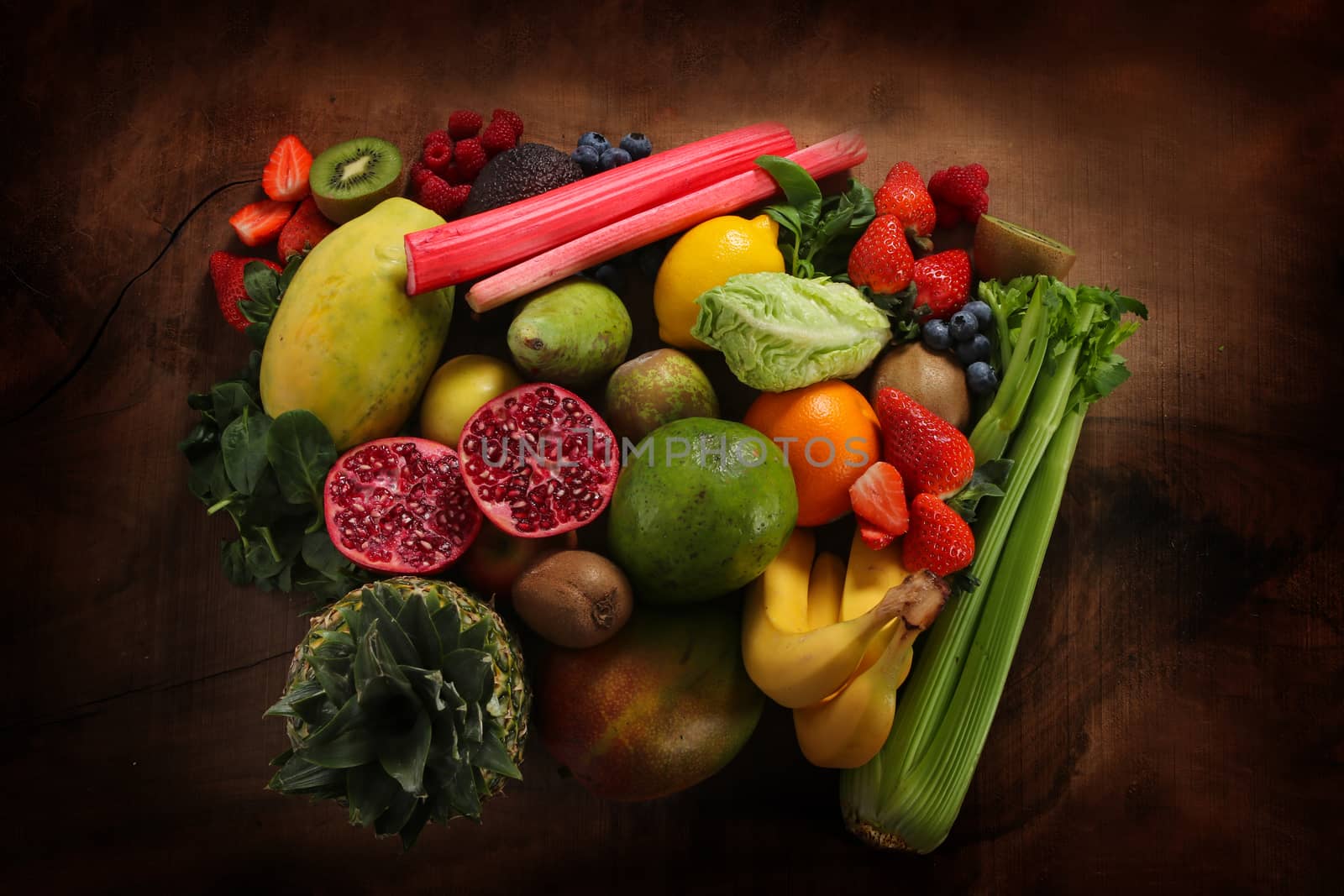 close up of raw healthy food and fruit with copy space, With pineapple, pomegranate and other fruit and vegetable on a wooden board