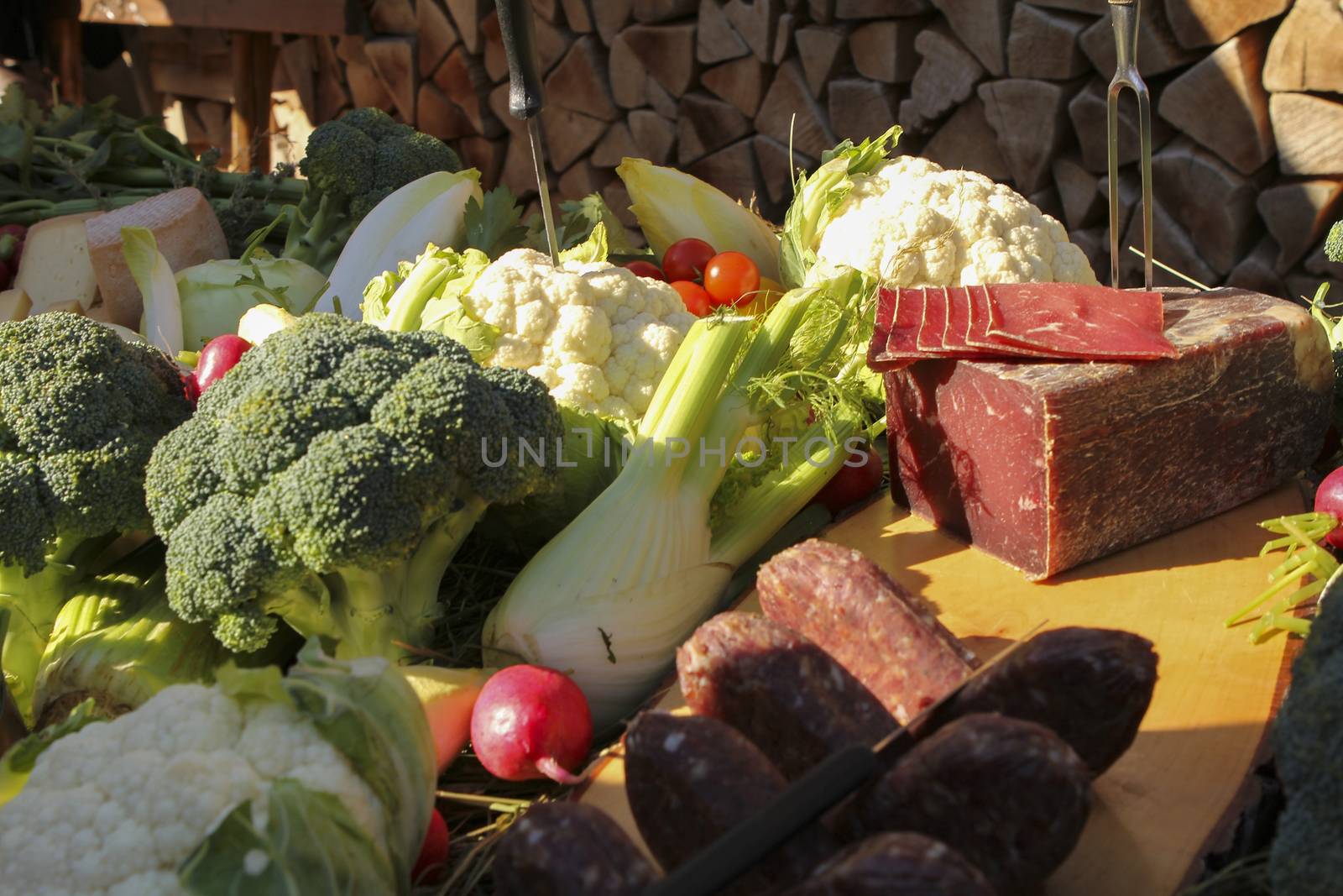 a good meal with wine. Shot from above with copy space and oval plates and a glass of wine with wood logs as background
