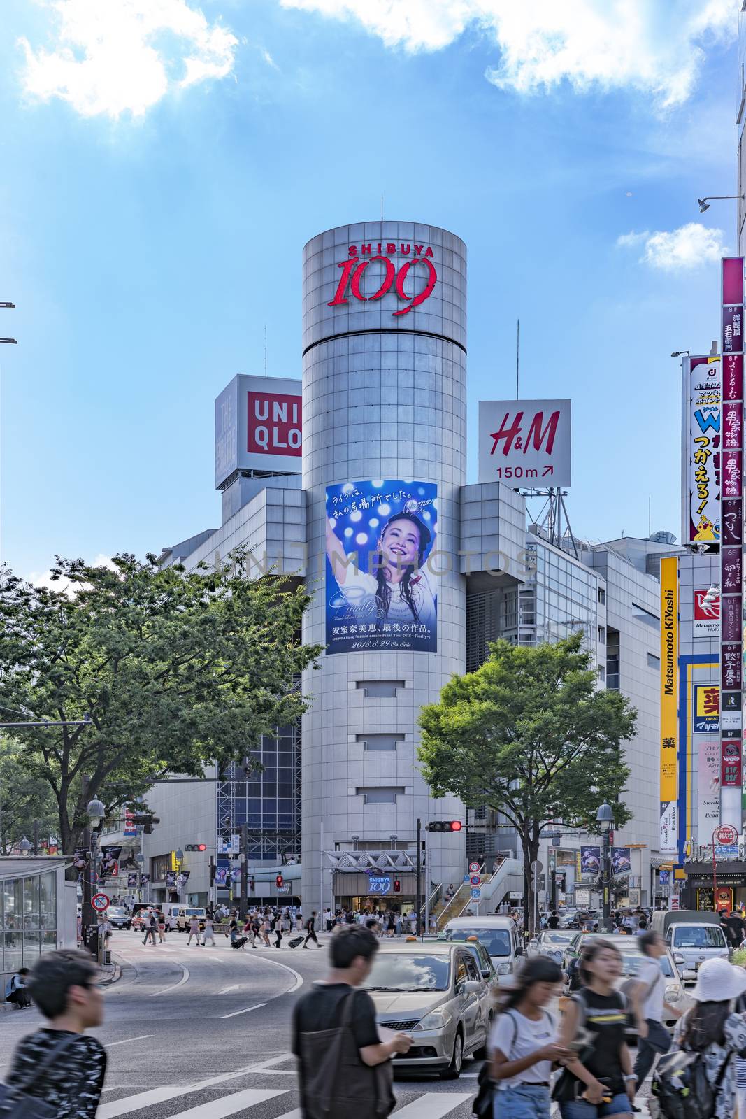 Shibuya Crossing Intersection in front of Shibuya Station on a bright day blue sky.