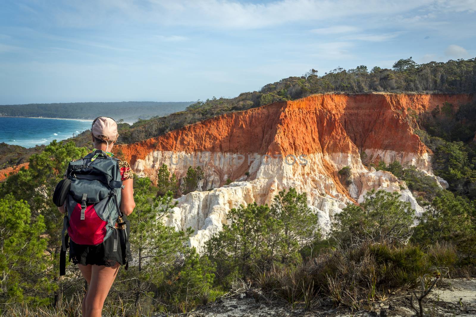 A woman traveller takes in the views of the amazing Pinnacles formation – a spectacular erosion feature that consists of cliffs of soft white sands capped with a layer of red gravel clay. It was deposited during the Tertiary geological period about 65 million years ago.