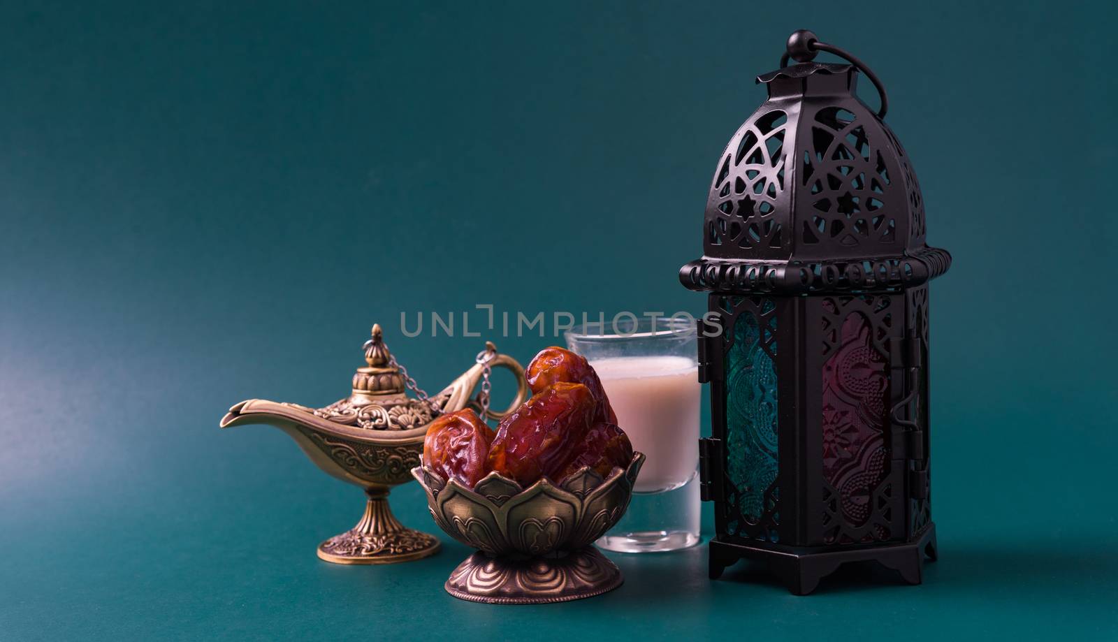 Ramadan Kareem fasting Food Concept, Bronze plate dates, milk, and lantern Aladdin lamp decoration, eid Arabian Muslim religious festival on a dark green background with copy space for text
