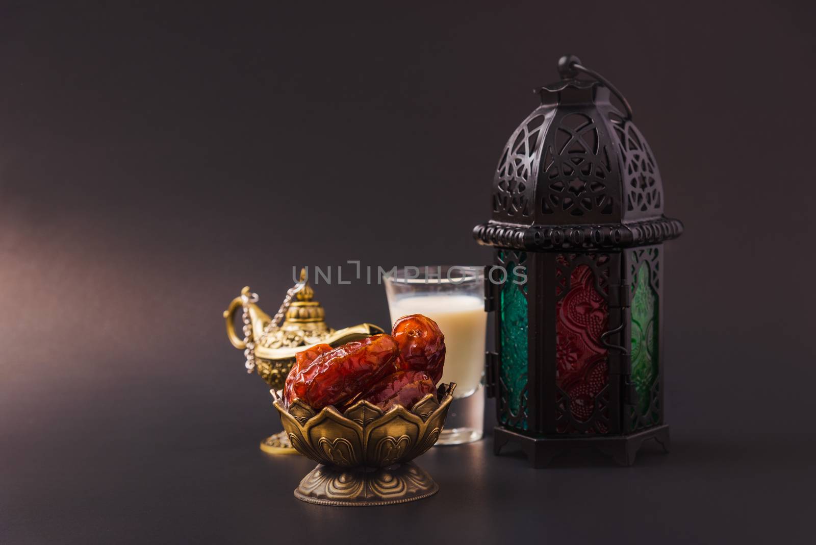 Ramadan Kareem fasting Food Concept, Bronze plate dates, milk, and lantern Aladdin lamp decoration, eid Arabian Muslim religious festival on a black background with copy space for text