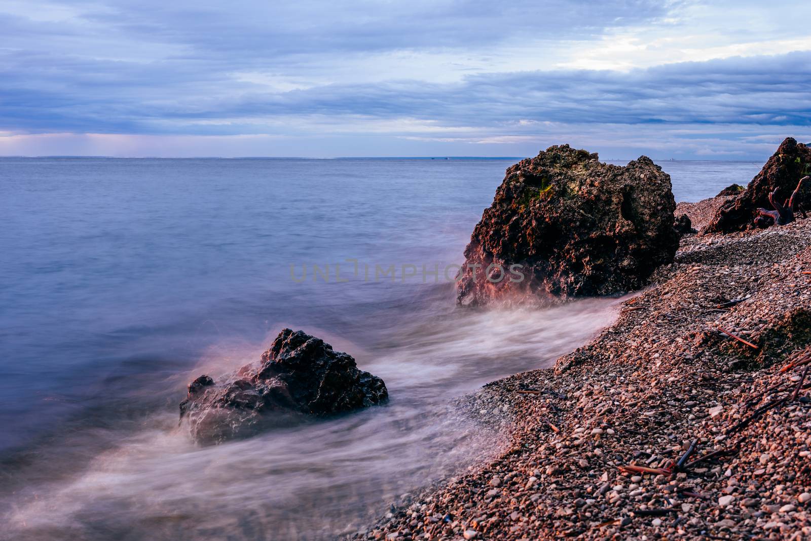 Boulders in sunrise light and smoothing waves by Seva_blsv