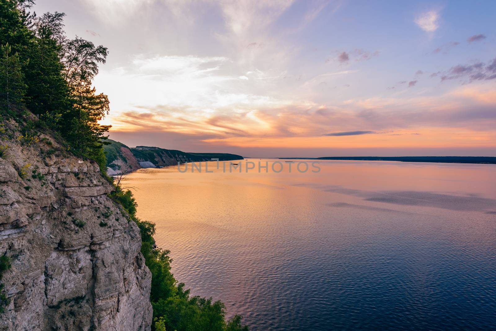 Sunset on river with reflected sky. Vew from cliff.