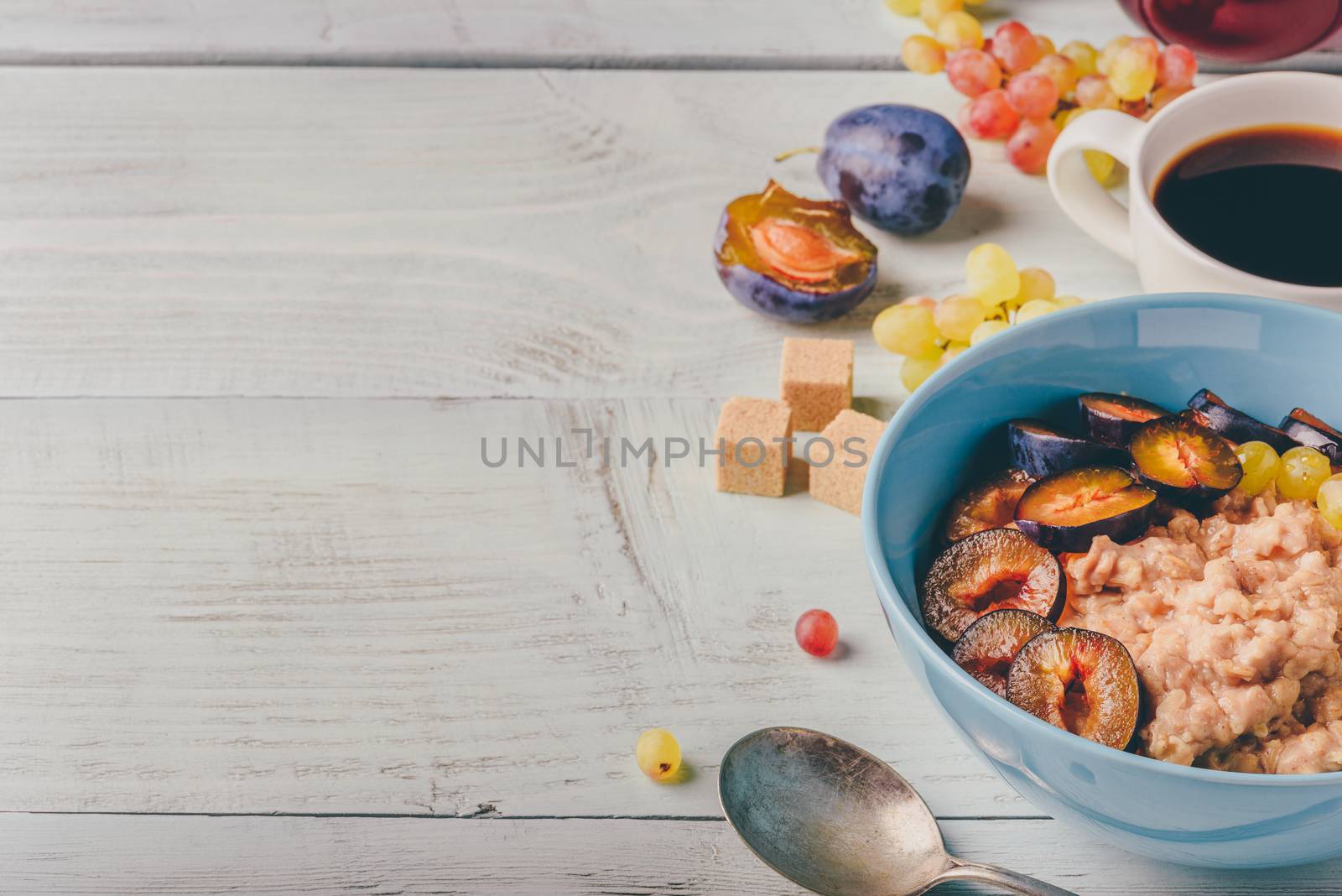 Porridge with plum, grapes and cup of coffee by Seva_blsv