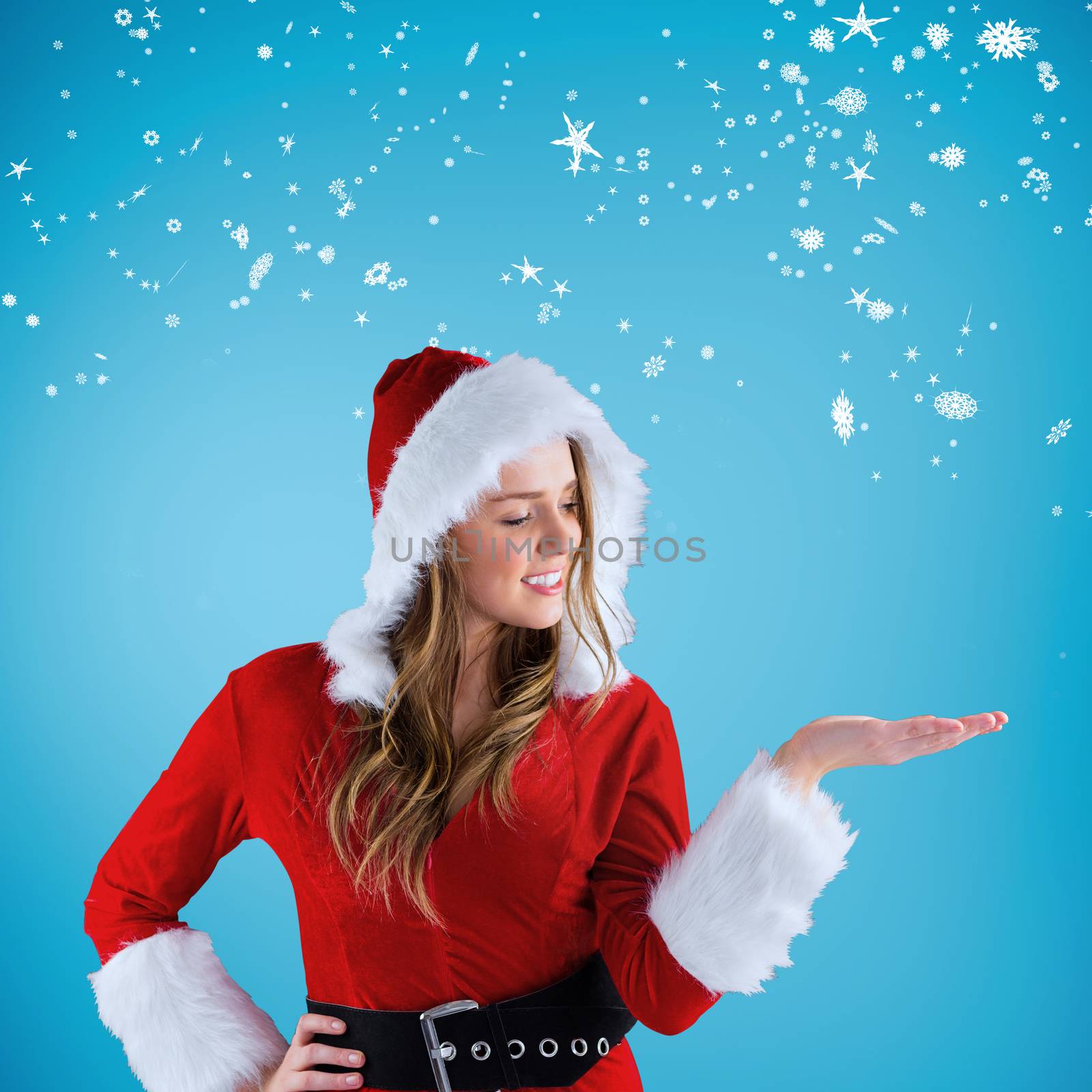Sexy santa girl presenting with hand against blue vignette