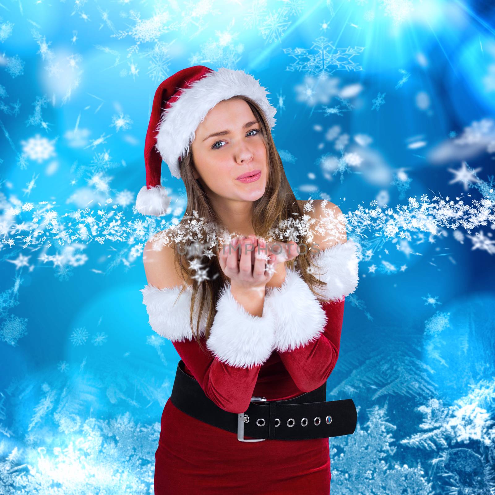 Sexy santa girl blowing over hands against blue snow flake pattern design