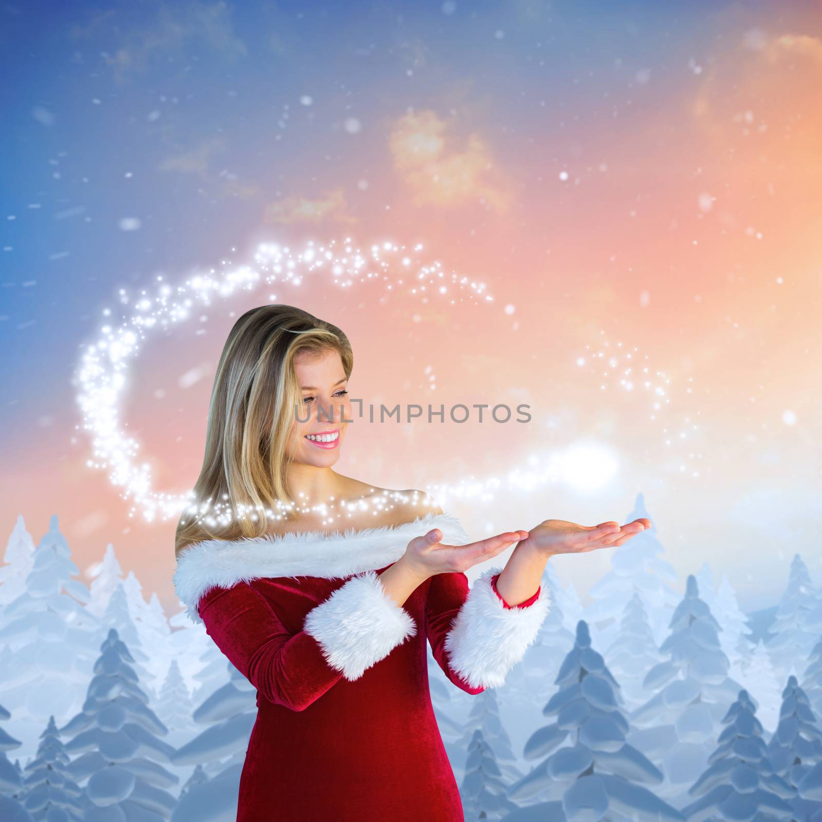 Pretty girl presenting in santa outfit against snow falling on fir tree forest