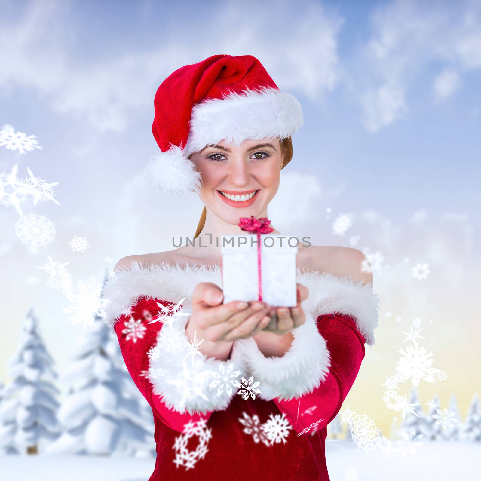 Pretty girl in santa costume holding gift box against snowy landscape with fir trees