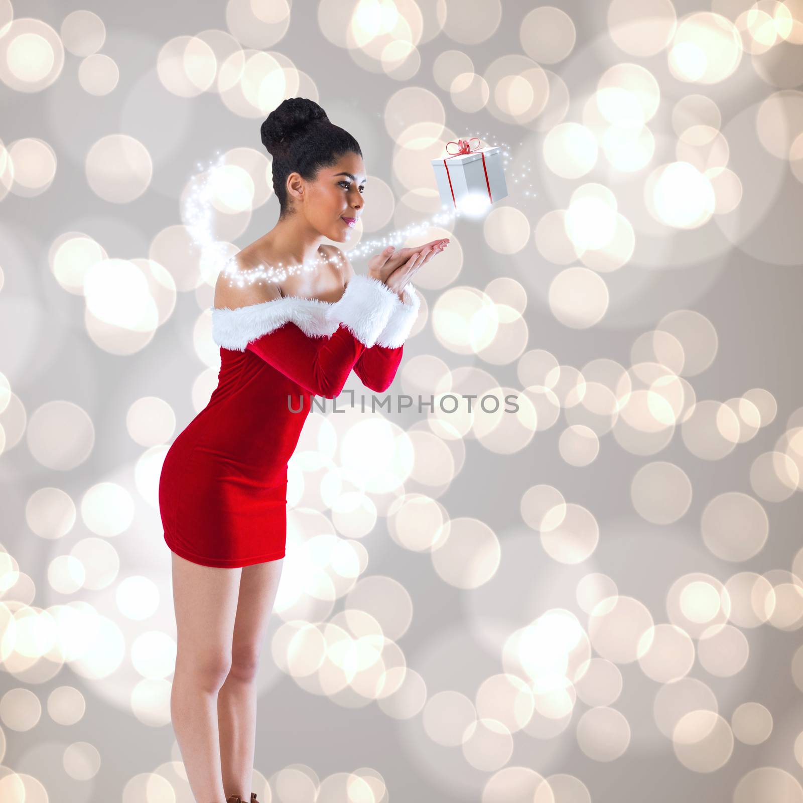 Pretty santa girl blowing over her hands against light glowing dots design pattern