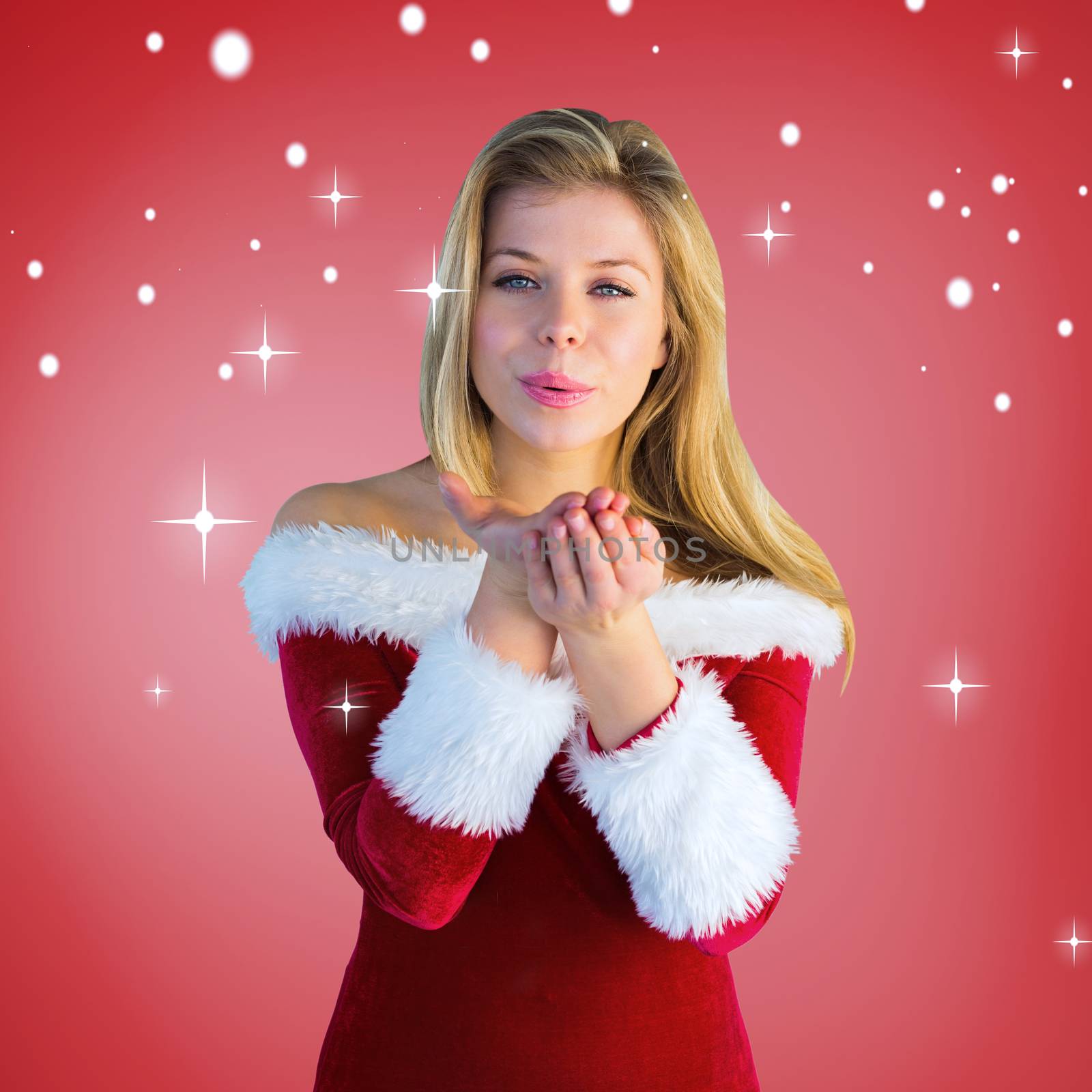 Composite image of pretty girl in santa outfit blowing by Wavebreakmedia