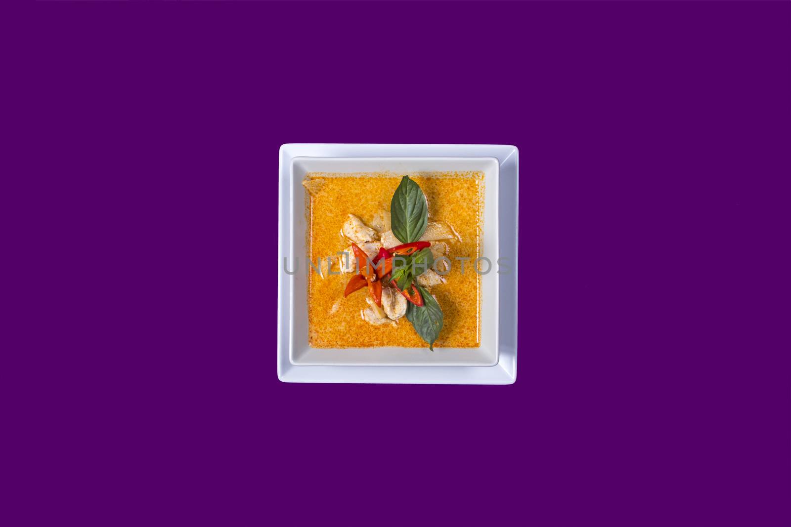 gang dang. Asian Thai food on white plates with purple background with copy space with green vegetable an