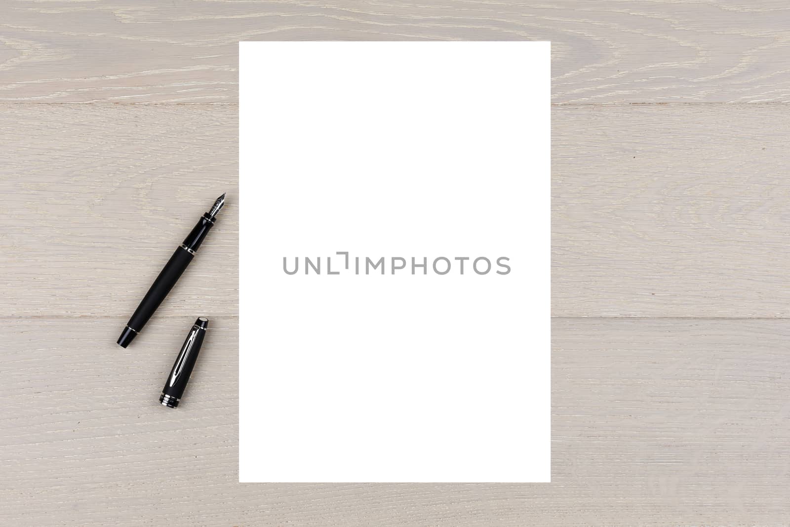 A4 white paper on light wood with ink fountain pen copy space by VivacityImages