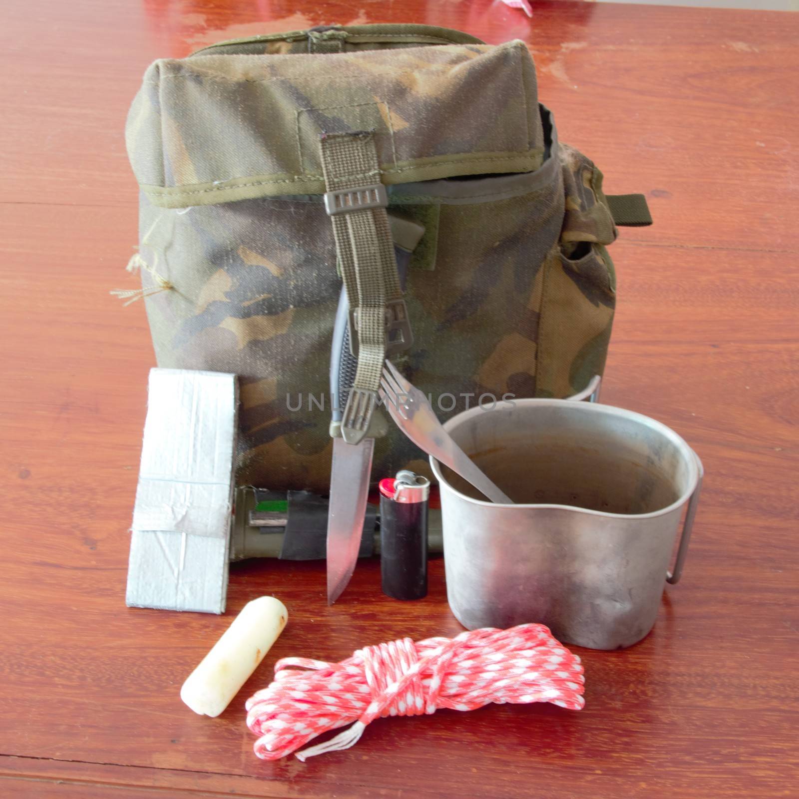 Survival pouch with tin cup, knife, paracord, tape, candle, flint and steel and lighter