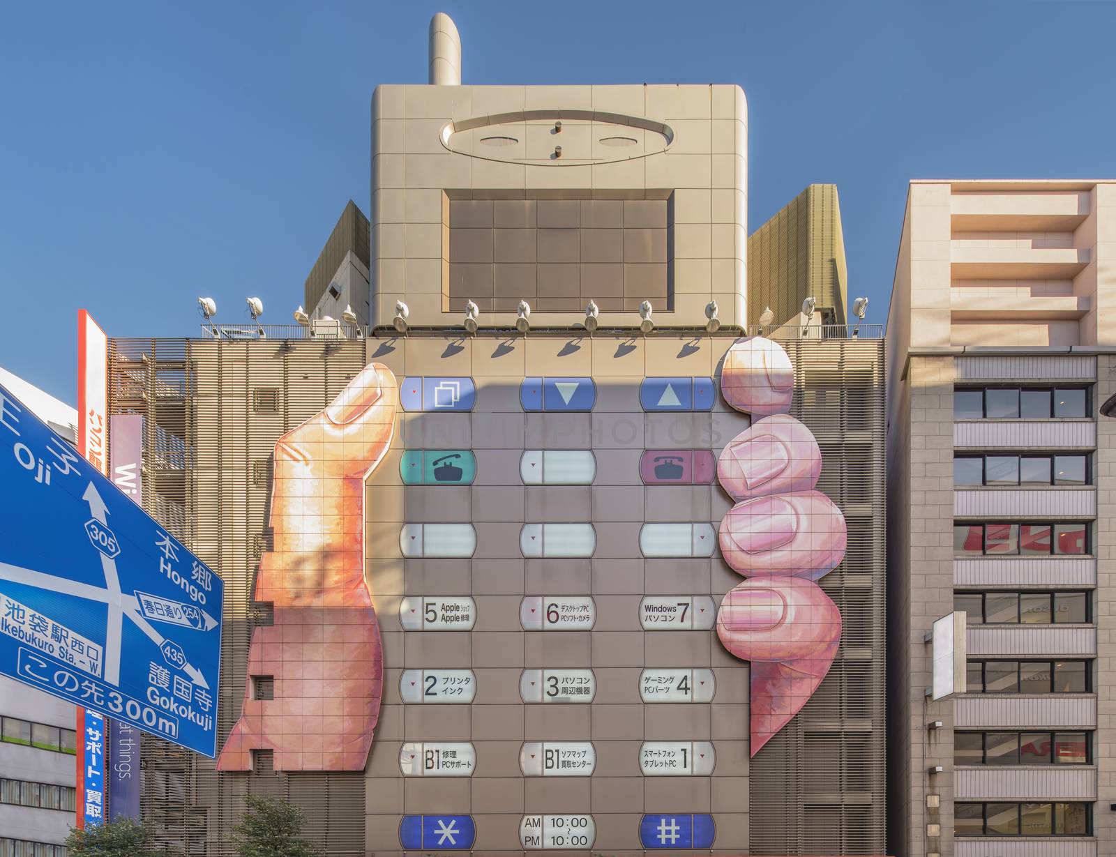 Building of a consumer electronics shopping center shaped in a form of a mobile phone held in one hand where the windows are button-shaped in Ikebukuro district north of Tokyo