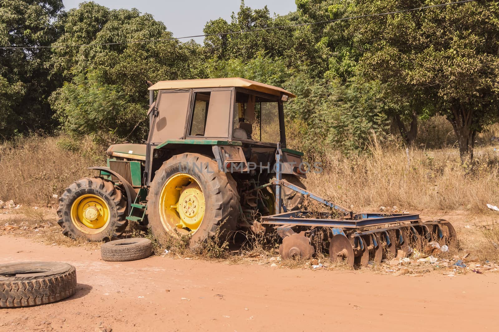Old rusty abandoned tractor on a dirt road in The Gambia