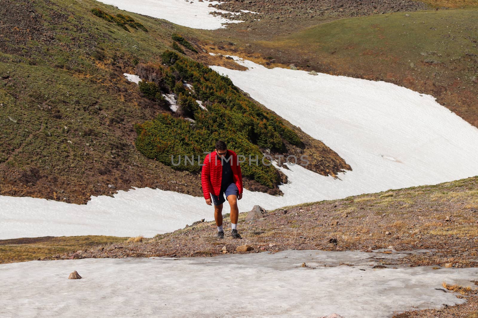 A man hiking along snow covered Colorado Mountains by gena_wells