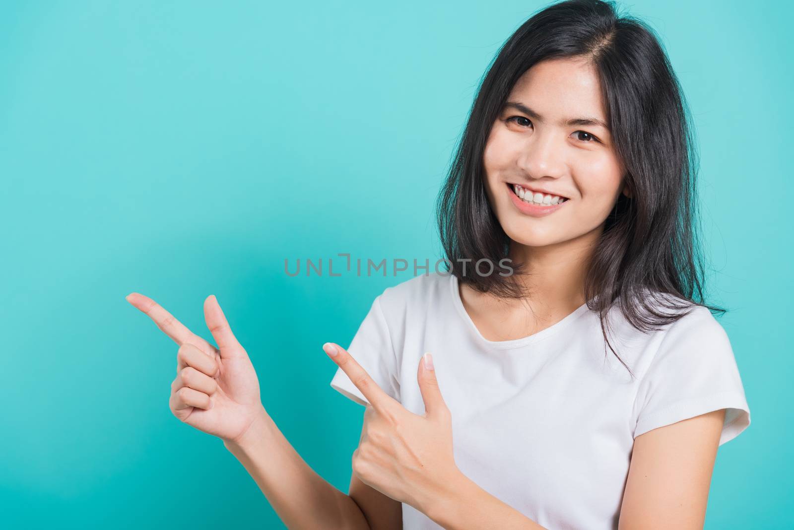Portrait Asian beautiful young woman standing pointing finger up by Sorapop