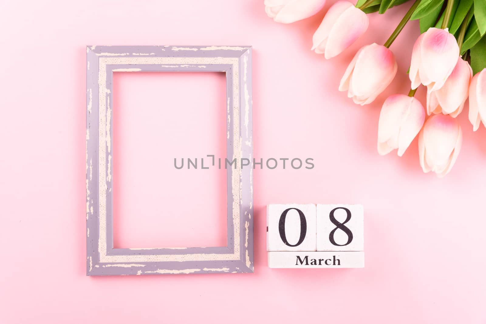Happy Women's Day, Mother's Day concept. top view flat lay Tulip flower and photo frame on pink background, copy space for your text