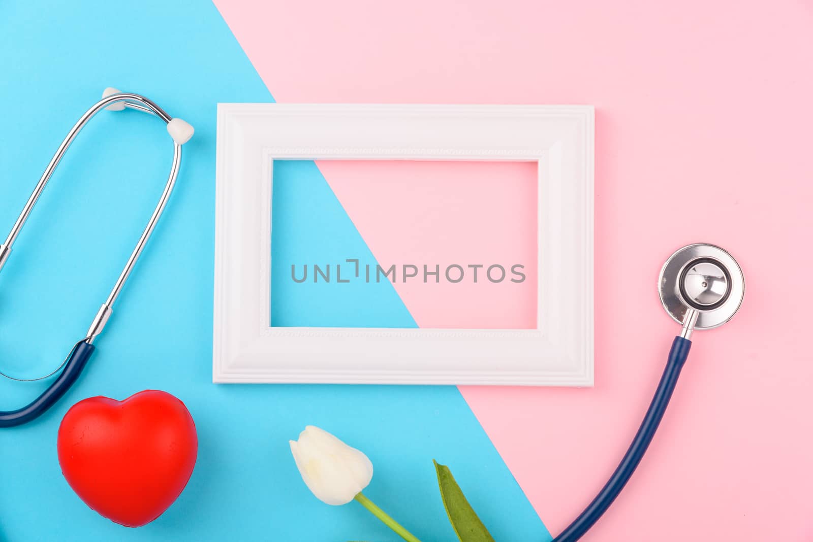 Doctor's Day concept, flat lay top view, stethoscope with photo frame and red heart on pink blue background, diagnosis of heart disease with copy space for text
