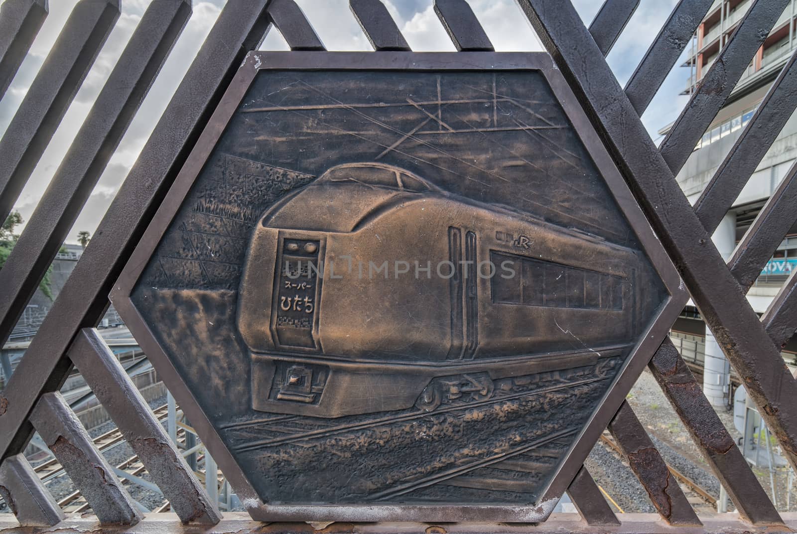 Engraving on metal representing the Super Hitachi train on the Shimogoindenbashi Bridge that reaches the Nippori and Yanaka neighborhoods in the Arakawa district at the north exit of the Nippori Station on the JR Yamanote Line in Tokyo. In the center of the bridge is a balcony called the Train Museum which allows to observe the 2500 trains that pass each day below. The bridge dating back to the 1930s has been renovated several times to adapt to the evolution of traffic and was completed in its current form in 1988.