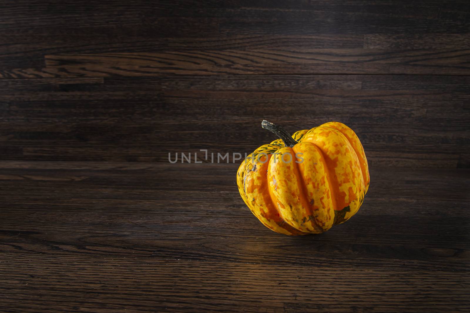 single orange sweet dumpling against a dark wood background