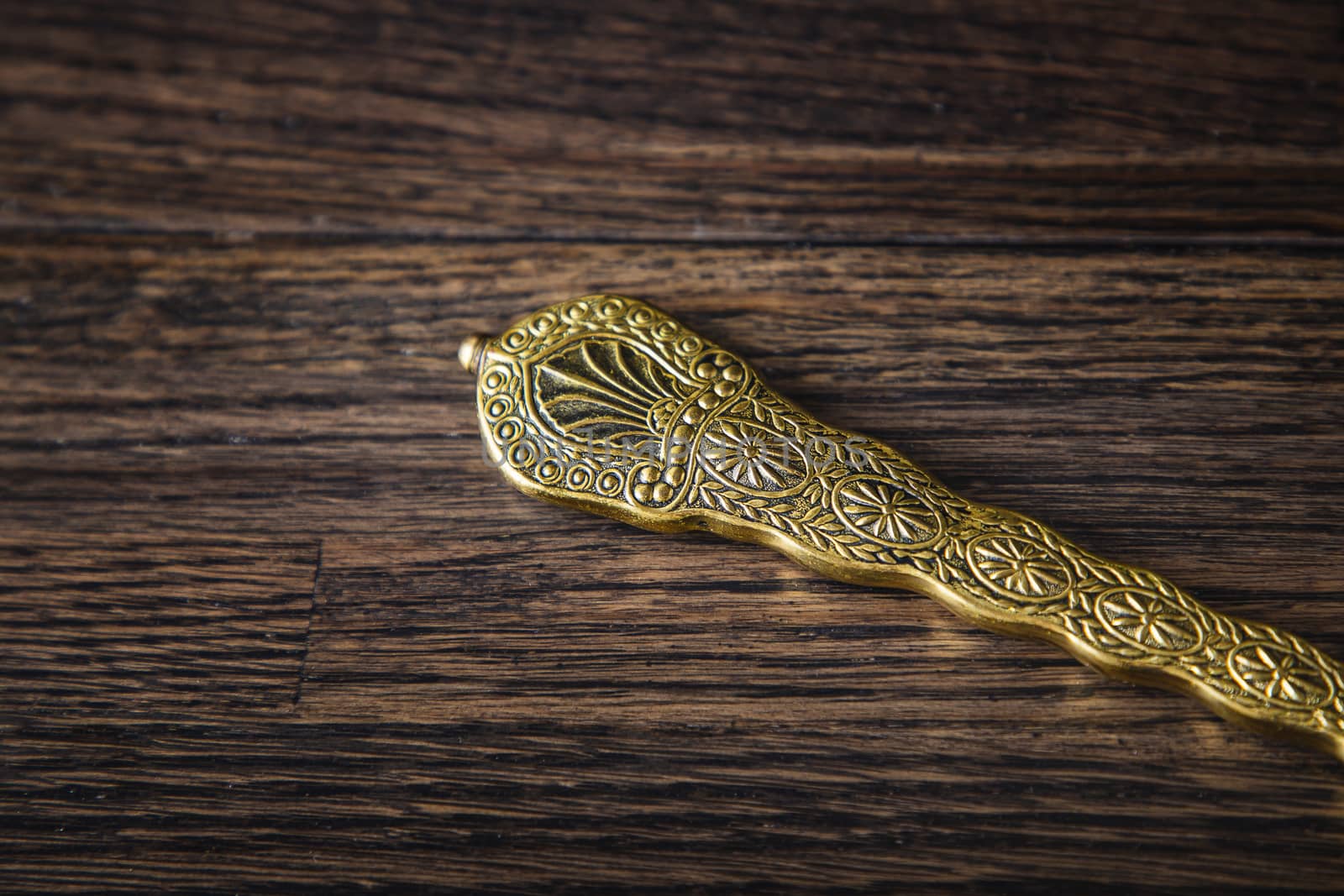 Vintage brush handle against a dark wood background