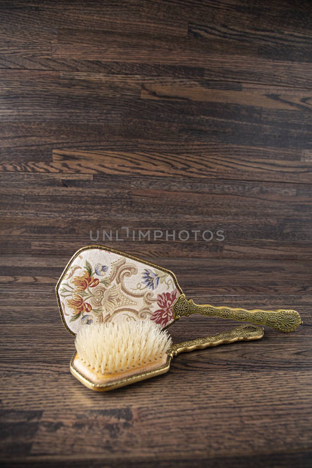 vintage beauty hair brush and mirror against a wood background