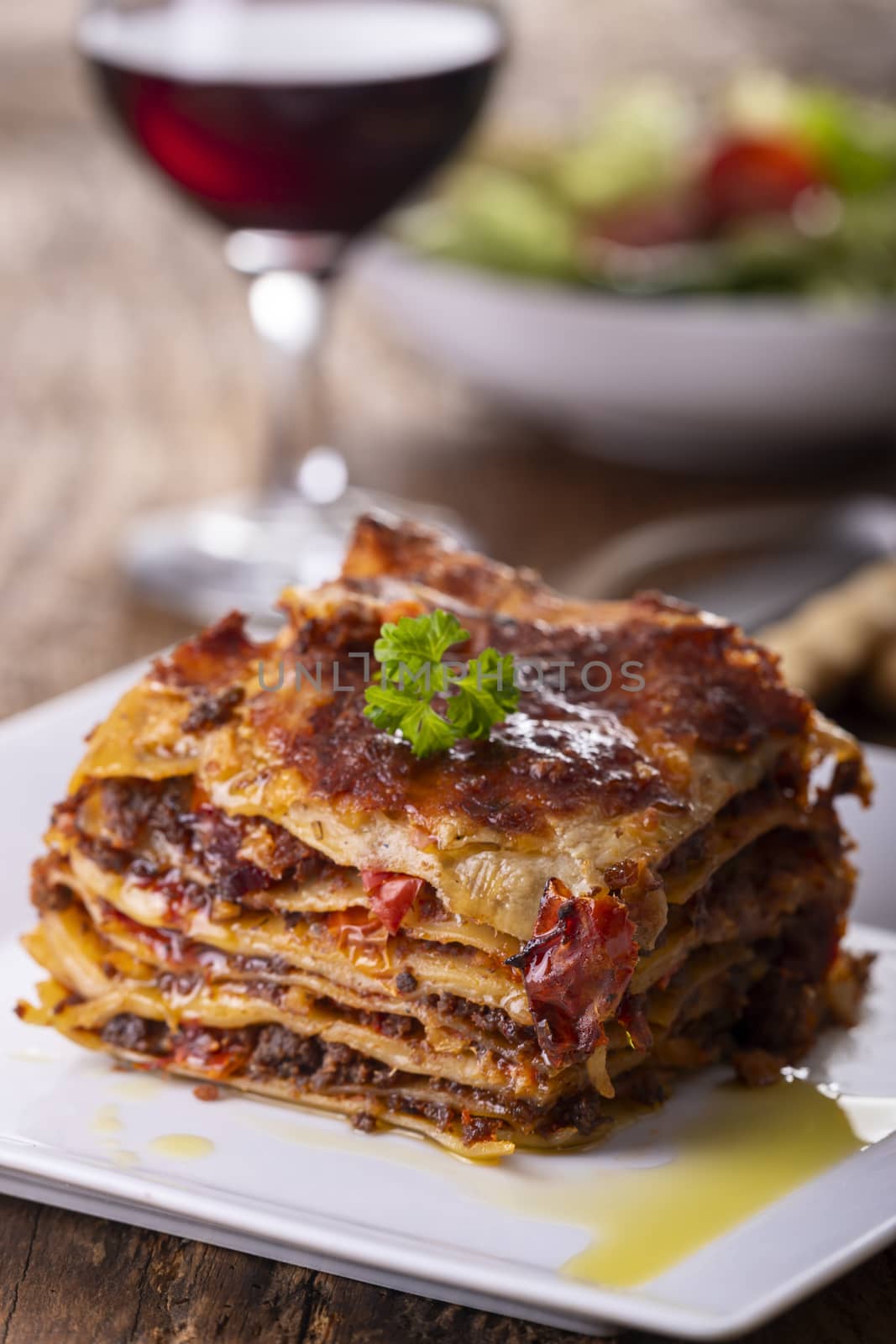 portion of lasagna on a plate by bernjuer