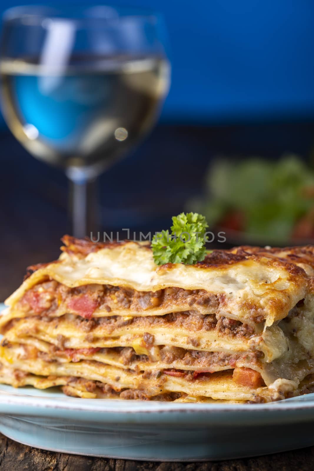 portion of fresh lasagna on a plate by bernjuer