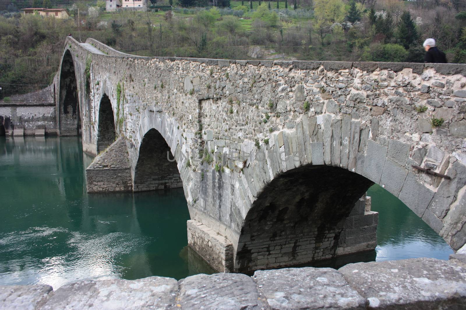 The suggestive and famous Ponte del Diavolo of Lucca built in bricks over a river in an ancient medieval village in Borgo a Mozzano by alessiapenny90