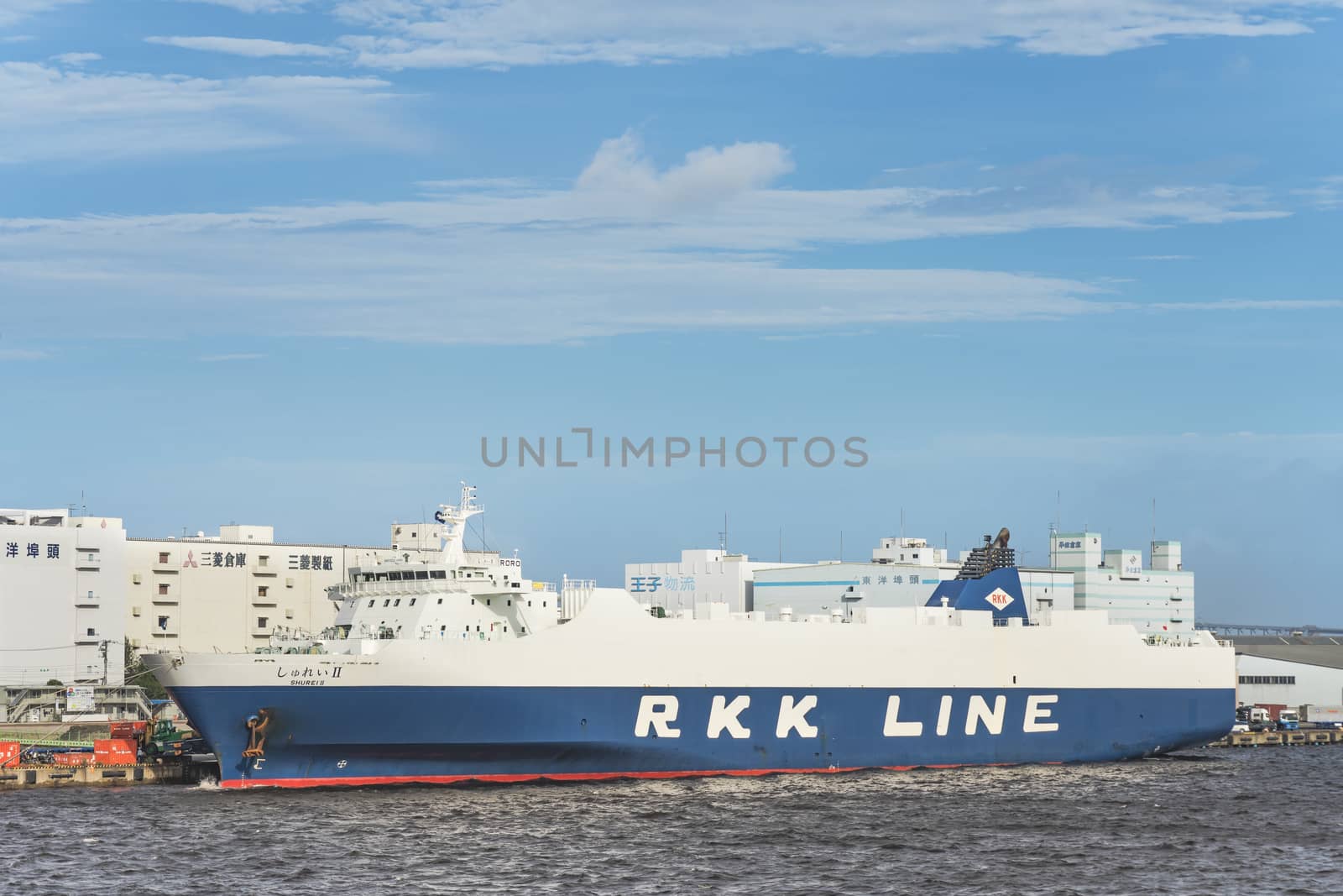 Giant cargo ship Shurei II from RKK LINE with the flag of Japan moored in the commercial port of Tokyo Bay.