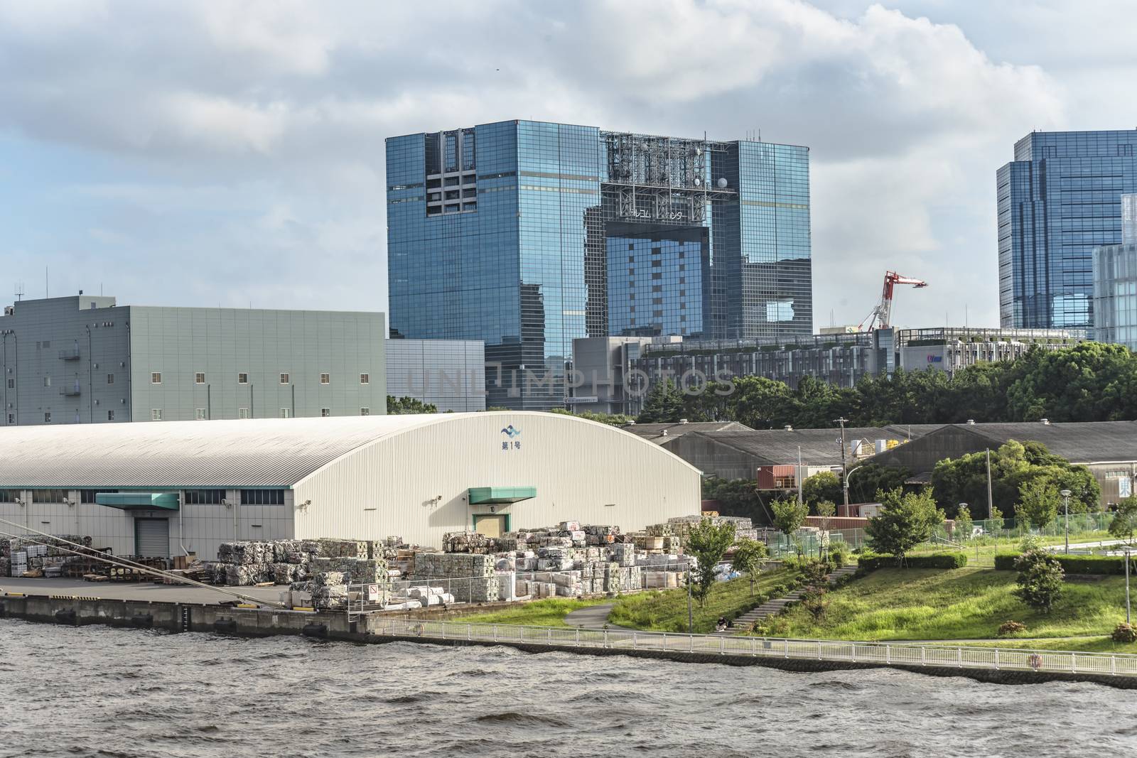 The Telecom Center glass covered arch building adjacent to Telecom Center Station in the bayside area of Odaiba in Tokyo, Japan. In the summer blue sky its shape  looks similar to France's Toit de la Grande Arche.