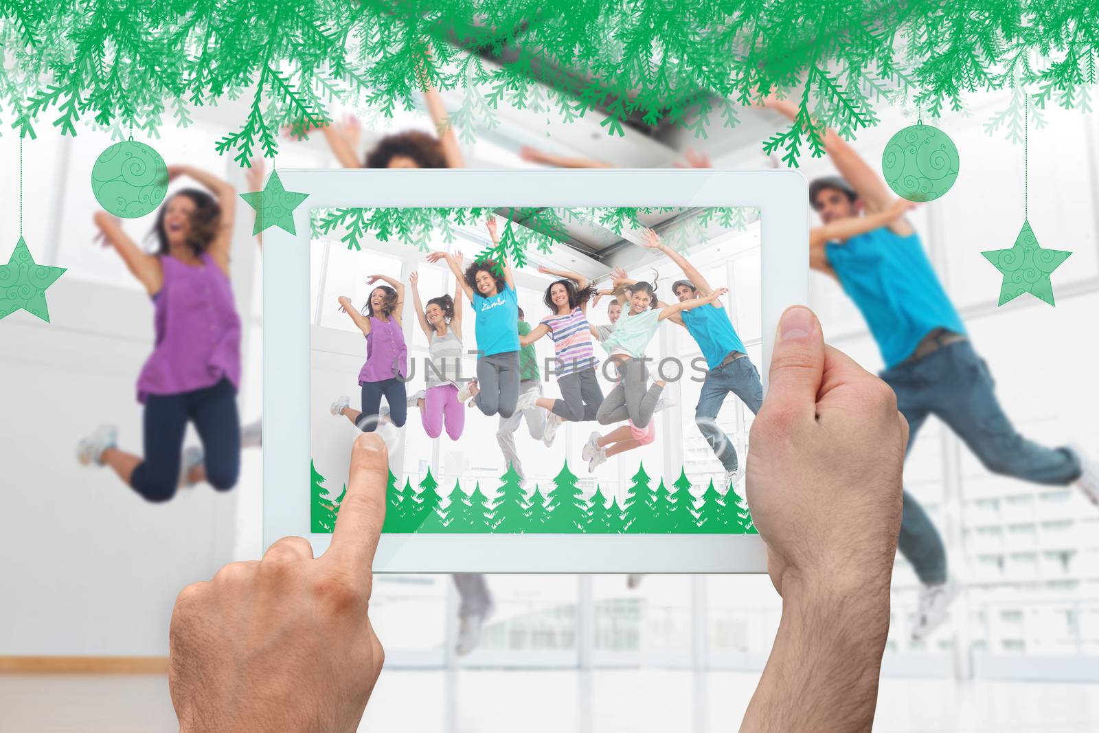 Hand holding tablet pc against fitness class and instructor doing pilates exercise