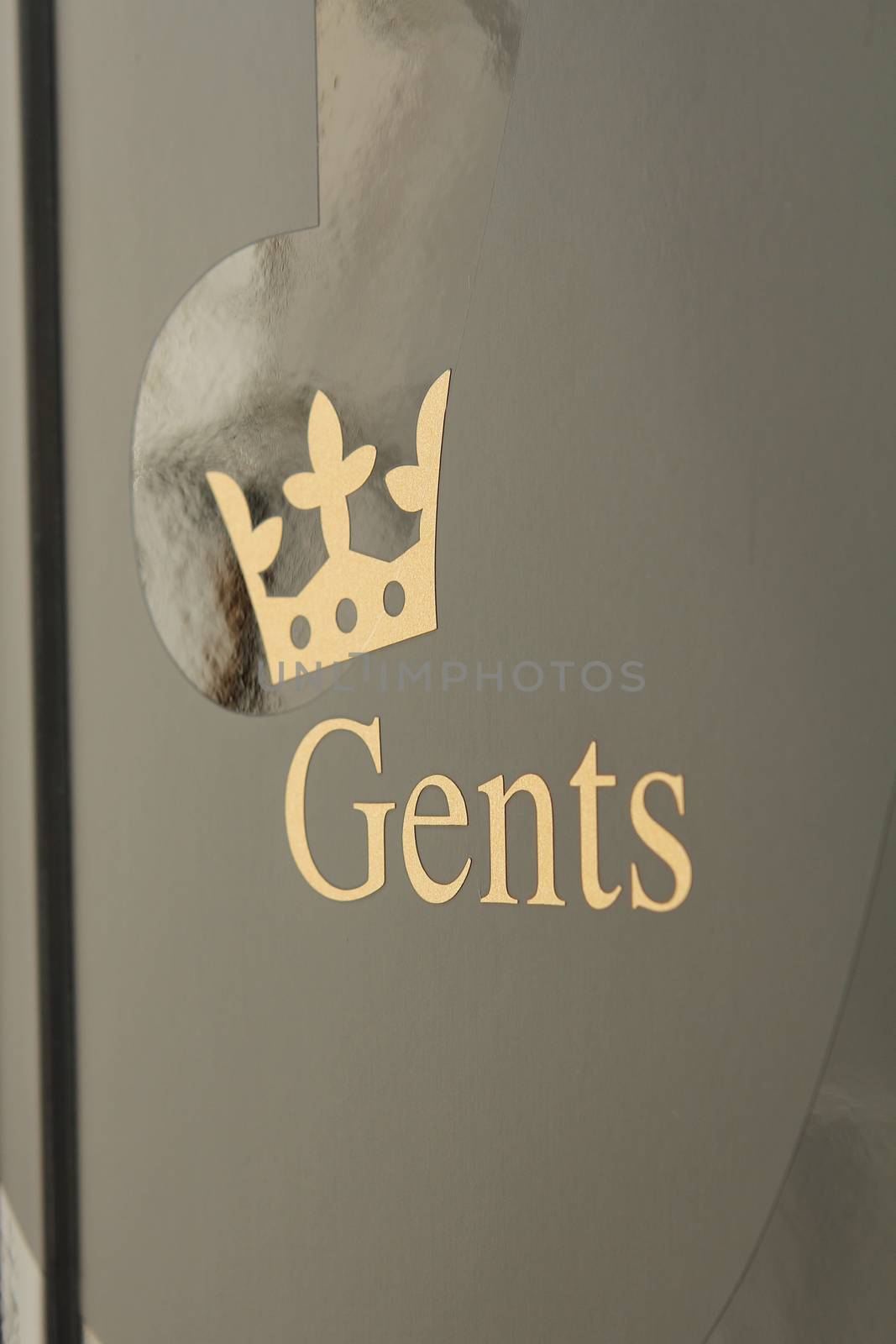 gents toilette icon on grey door with a crown
