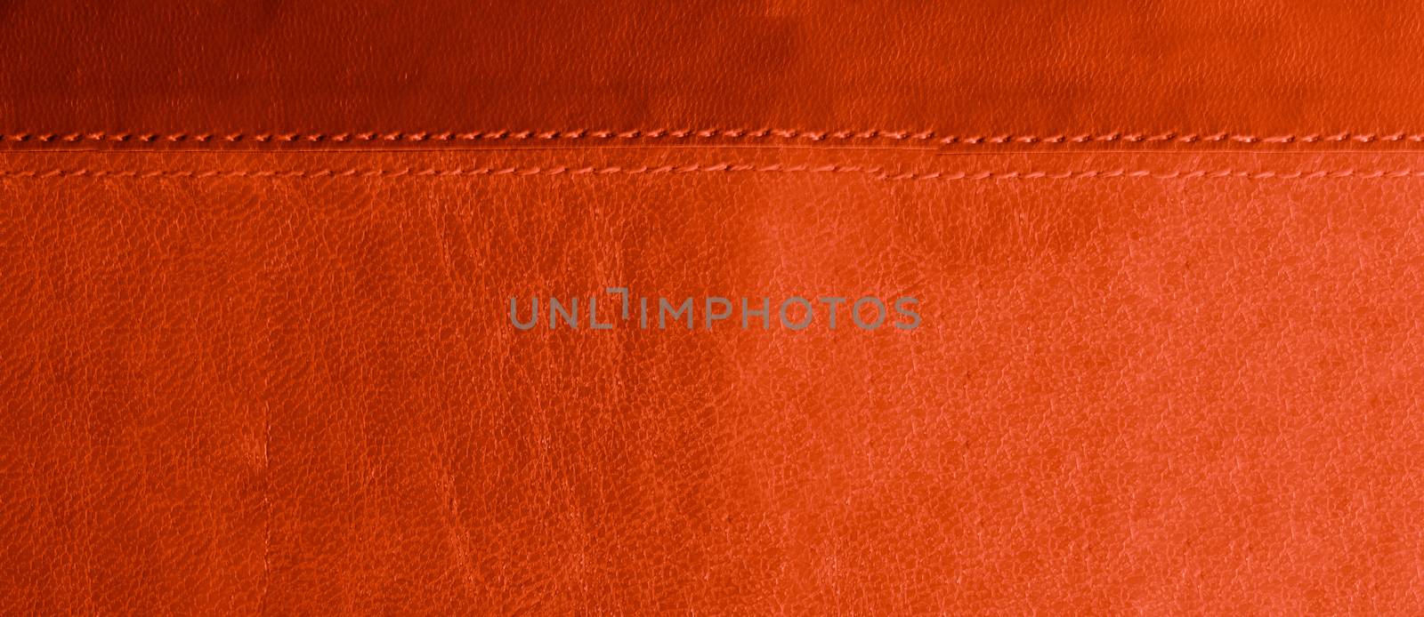 red and orange leather background with red stitches at the bottom