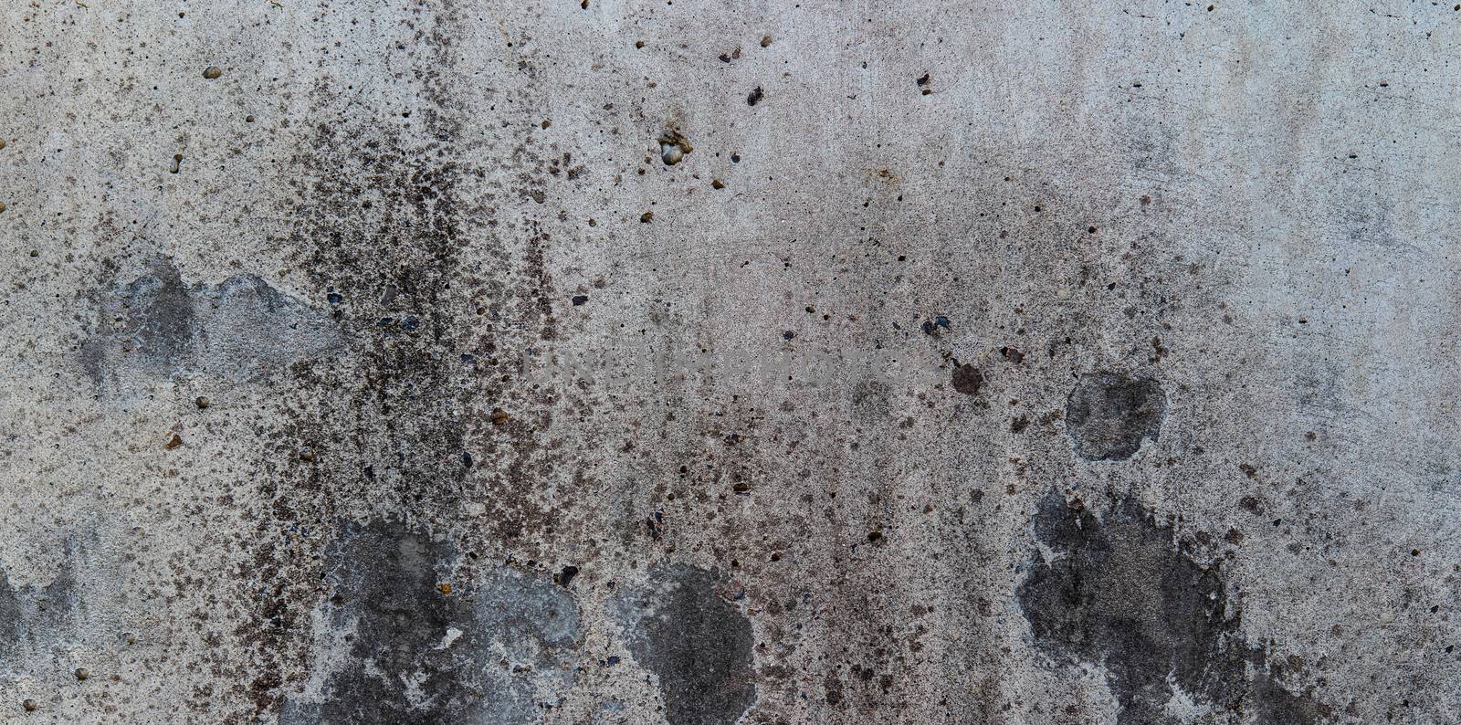 grey cement wall with dark spots l with dirt spots for background use.