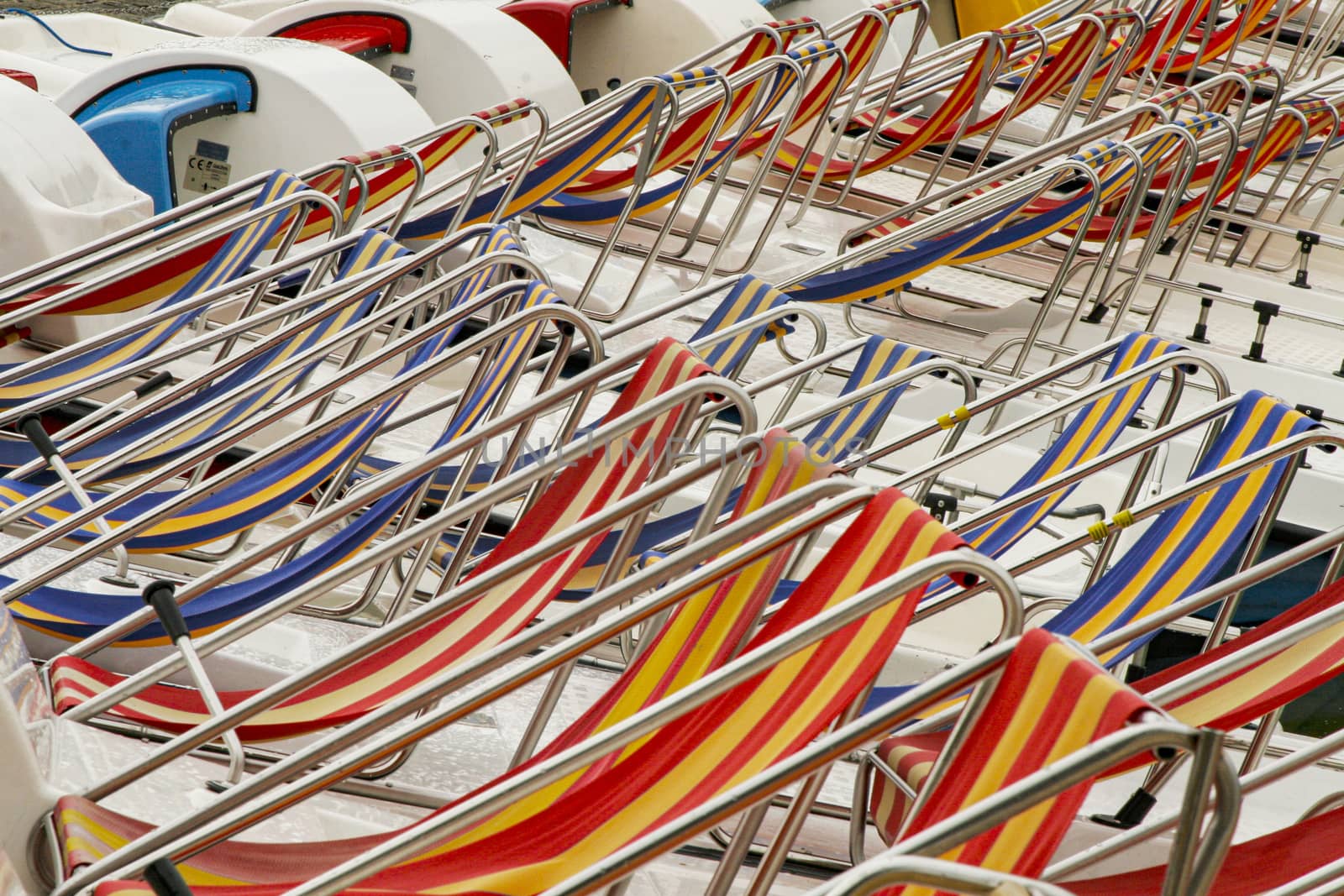 Row of colorful chaise lounge on beach. Multicolored in a row.