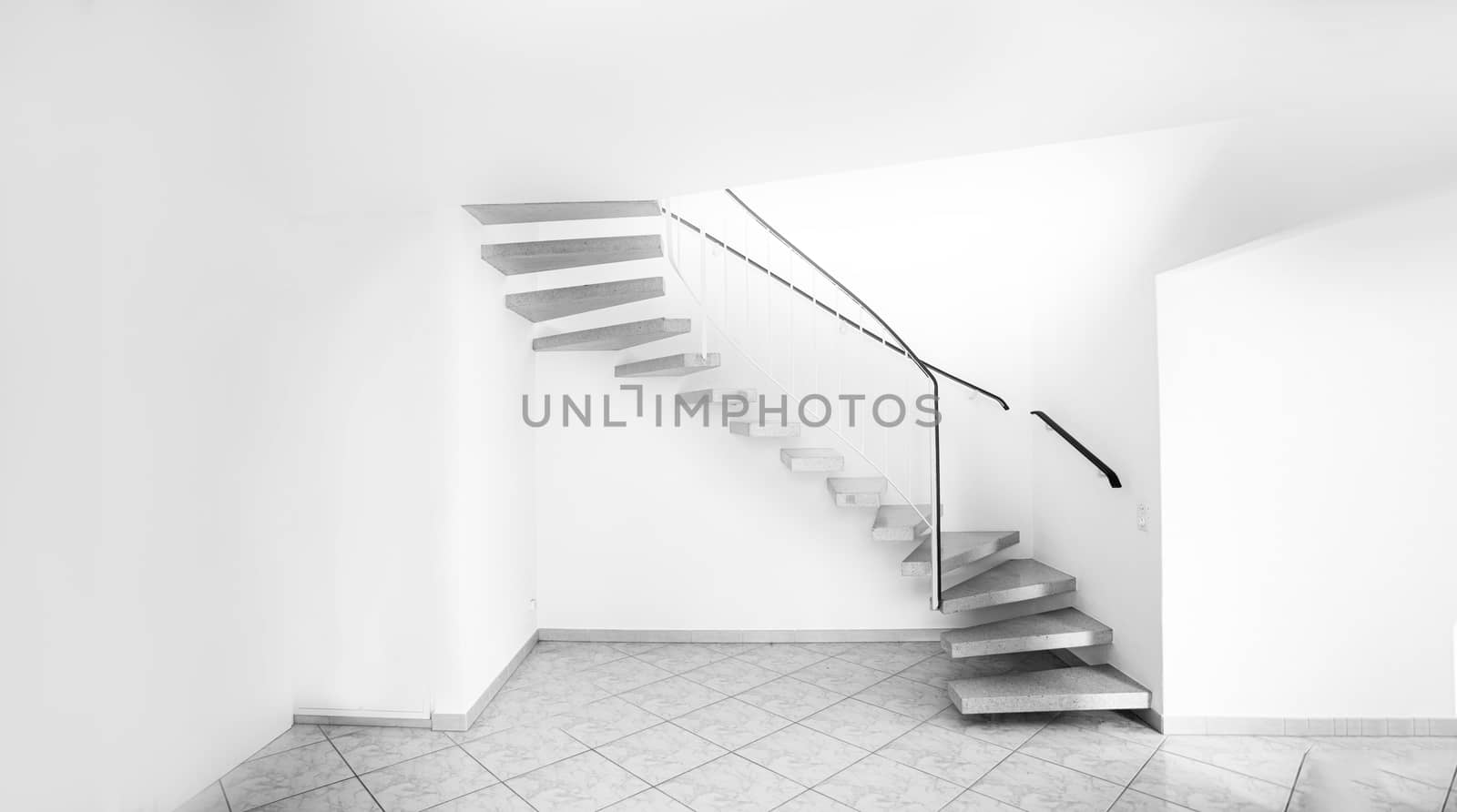 twisted staircase in clean white building leading up to second floor with white walls