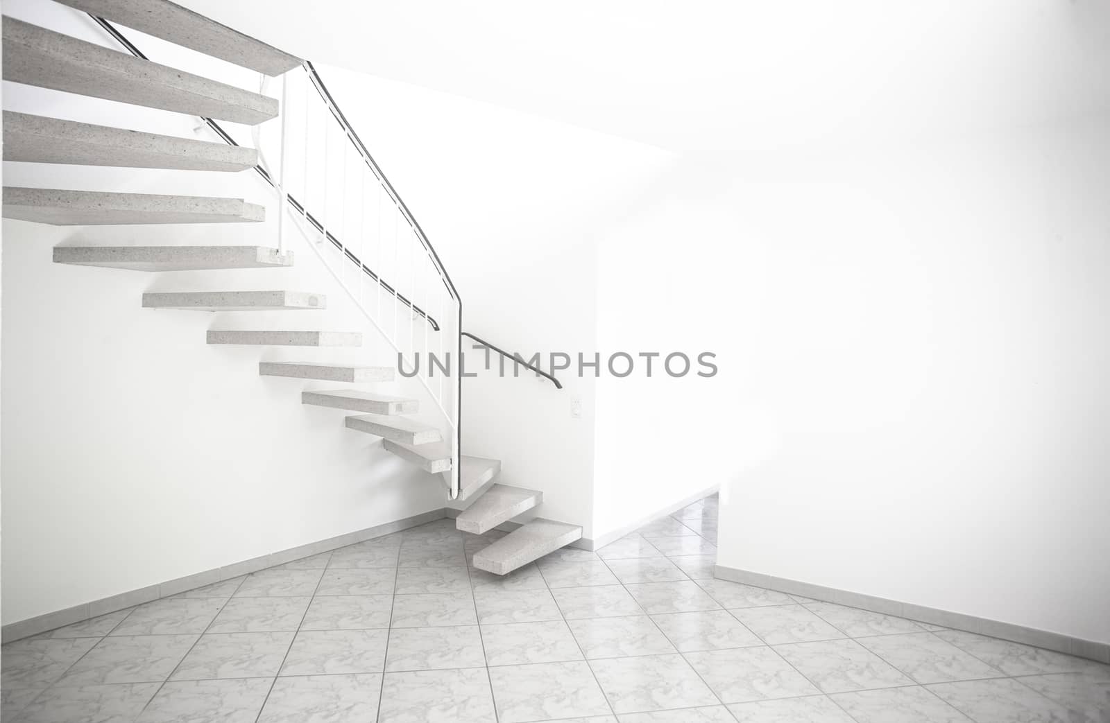 twisted staircase in clean white building leading up to second floor with white walls and doors