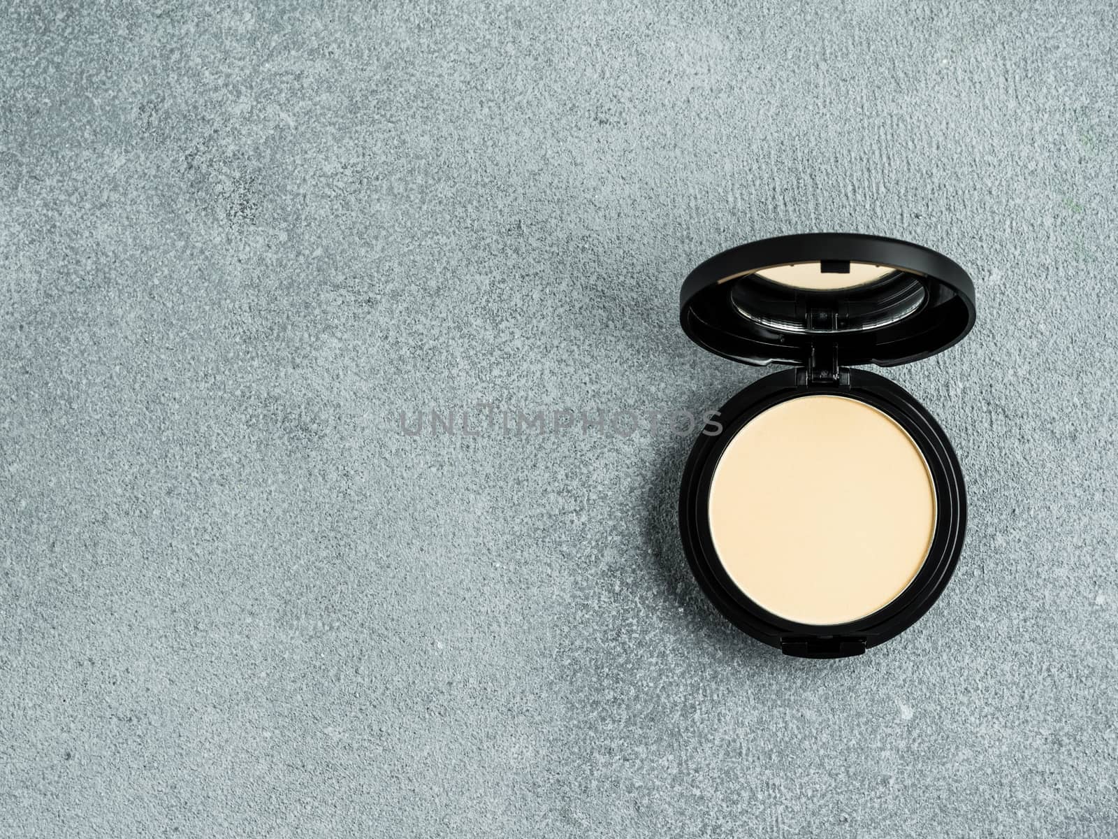 Compact powder on gray, copy space, top view by fascinadora