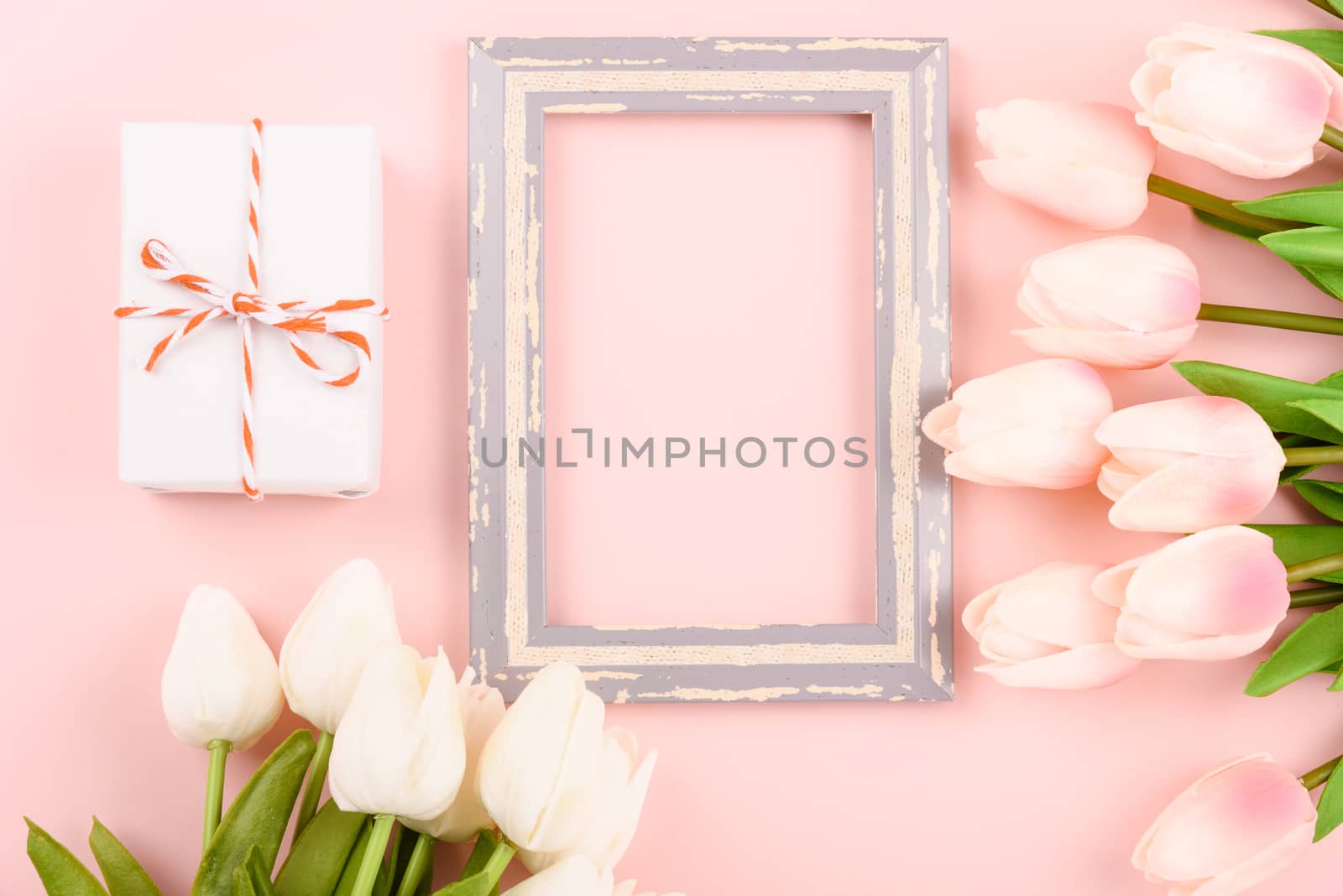 Happy Women's Day, Mother's Day concept. top view flat lay photo frame, gift box and Tulip flower on pink background, copy space for your text