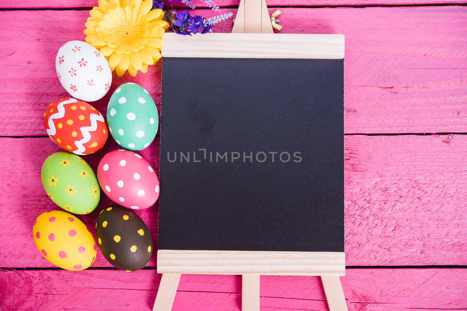 Easter eggs top view on pink wooden background and have board work space board for use