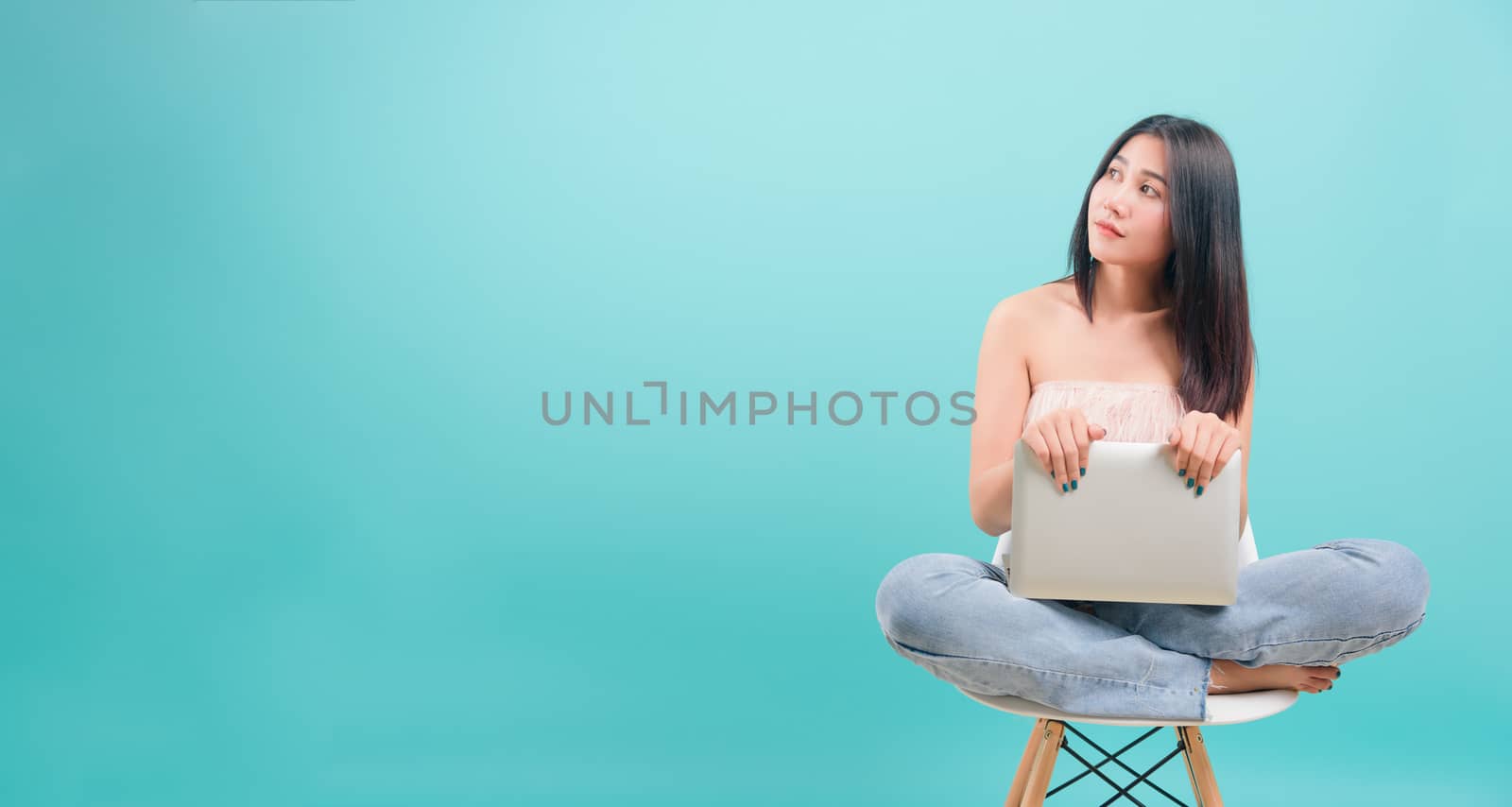 woman sitting on chair smile her  holding laptop computer by Sorapop