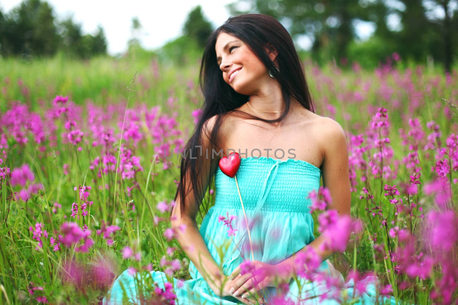 woman on summer flower field meadow heart in hands love nature