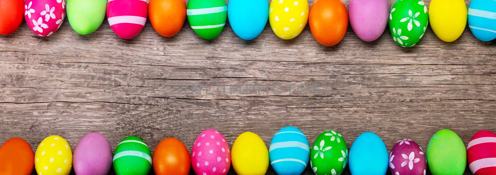 Colorful easter eggs on old brown wooden board card banner with copy space for text